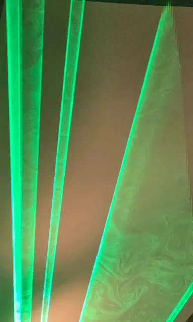 Green laser beams cutting through haze